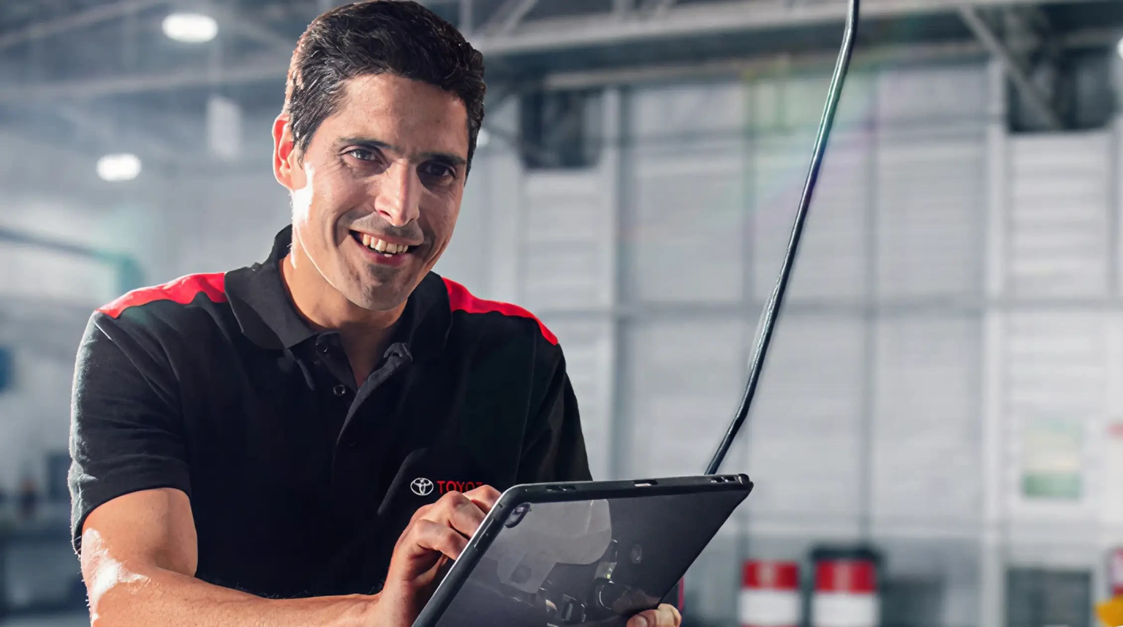 Homem com uniforme Toyota segurando um tablet
